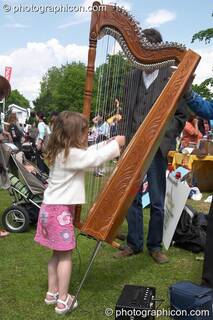 Young girl plays a harp at Kingston Green Fair 2005. Kingston Upon Thames, Great Britain. © 2005 Photographicon