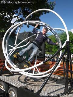 A guy on a full-motion gyroscope at Kingston Green Fair 2005. Kingston Upon Thames, Great Britain. © 2005 Photographicon
