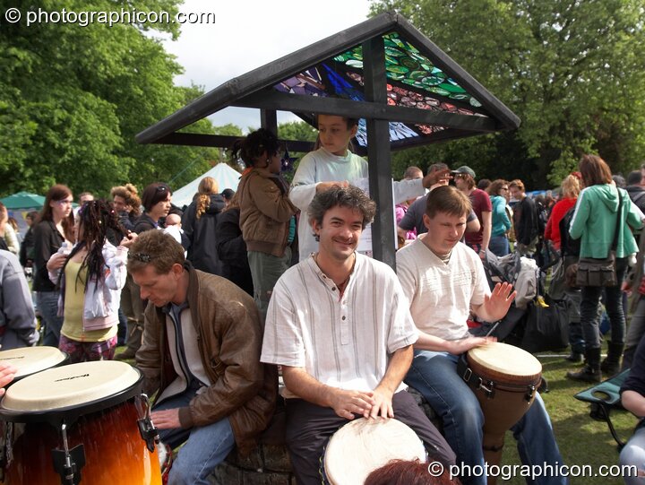 An impromptu drumming session around the Rainbow Wishing Well at Kingston Green Fair 2006. Kingston upon Thames, Great Britain. © 2006 Photographicon