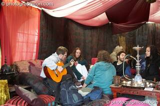 A group of friends jam inside of a small Shisha-style chillout tent at Kingston Green Fair 2008. Kingston upon Thames, Great Britain. © 2008 Photographicon