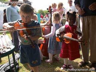 Children play with a instruments provided by Surrey Strings at the London Green Lifestyle Show 2005. Great Britain. © 2005 Photographicon