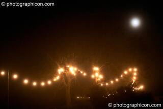 The moon in the mist above a long trail of fairy lights at the Lost Vagueness Summer Party 2004. Lewes, Great Britain. © 2004 Photographicon