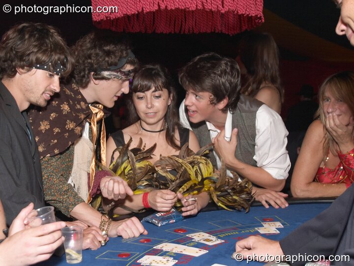 Man discusses his hand on the casino card table at the Lost Vagueness Summer Party 2004. Lewes, Great Britain. © 2004 Photographicon