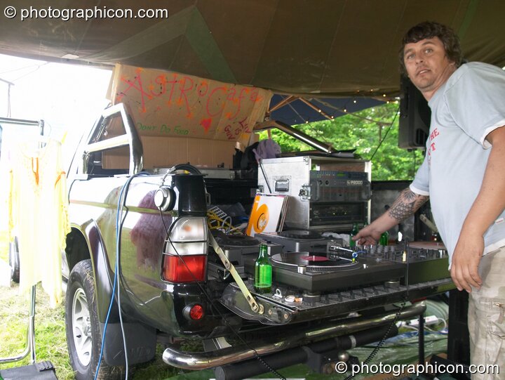Man DJing from the back of a 4x4 in the Astro Cafe at Wing Makers Solstice 2005. Launceston, Great Britain. © 2005 Photographicon
