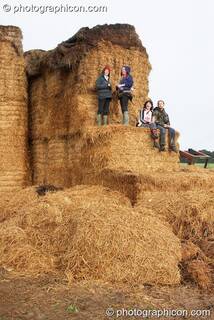 People enjoying the view from the side of a giant hay stack at the Echo Festival. Overton, Great Britain. © 2007 Photographicon