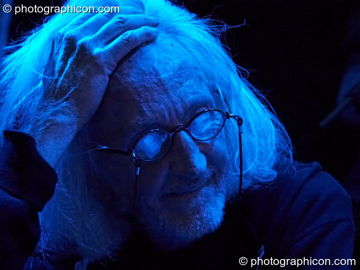 Daevid Allen sits pensively in blue light at Gong Poesy Electrique at inSpiral Lounge 21/08/2009. London, Great Britain. © 2009 Photographicon