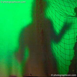 Shadow of woman dancing behind a hanging cloth at The Synergy Project. London, Great Britain. © 2005 Photographicon