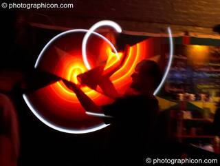 Jedi Juggler with illuminated flashing Glow Staffs, trail-blurred by slow shutter speed, at The Synergy Project. London, Great Britain. © 2006 Photographicon