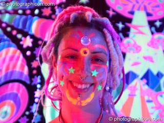 Girl with UV painted face stands in front of a space invader backdrop at The Synergy Project. London, Great Britain. © 2006 Photographicon