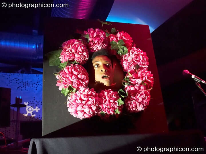 Dre performs with her elastic face in a bed of flowers on the Binglybongly stage at The Synergy Project. London, Great Britain. © 2006 Photographicon