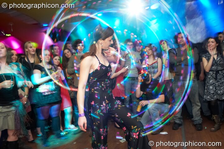A woman skilfully twirls an illuminated Hoola Hoop in the Galactic Fantastic room at The Synergy Project. London, Great Britain. © 2008 Photographicon