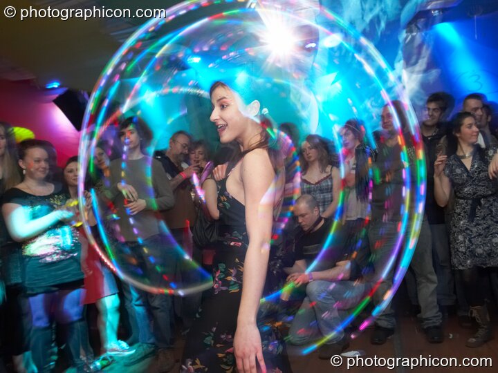 A woman skilfully twirls an illuminated Hoola Hoop in the Galactic Fantastic room at The Synergy Project. London, Great Britain. © 2008 Photographicon