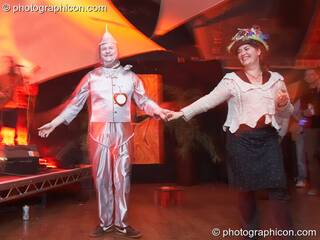 Costumed man dressed as the Tin Man (Wizard of Oz) dances with a female partner in the Small World room at The Synergy Project. London, Great Britain. © 2007 Photographicon