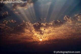The setting sun through the gaps in the cloud at Agios Pavlos. Greece. © 2002 Photographicon