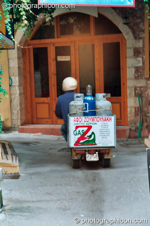 Man on scooter delivers large gas bottles in Rethymno. Greece. © 2002 Photographicon