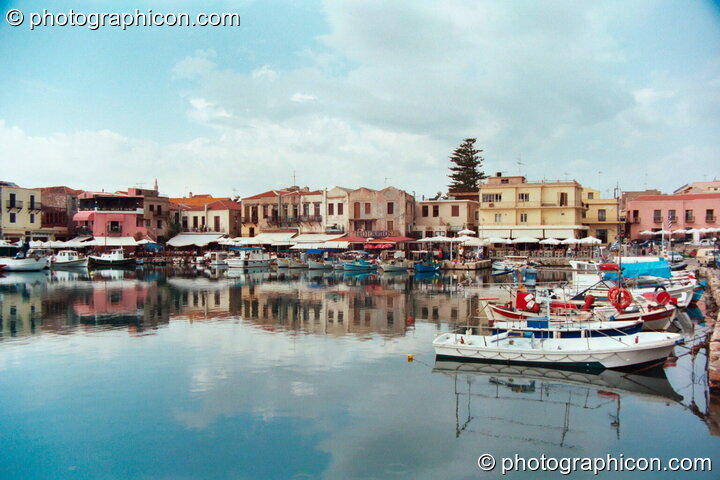 Boats and buildings reflected in the water of the harbour at Rethymno. Greece. © 2002 Photographicon