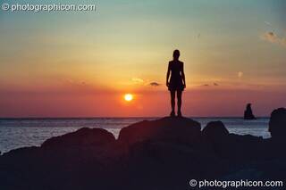 Woman looks out to sea, silhouetted by the golden sunset at Agios Pavlos. Greece. © 2002 Photographicon