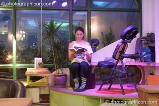 A woman reads a book by the massage chair in the inSpiral Lounge organic cafe and multimedia venue. London, United Kingdom. © 2008 Photographicon