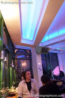 A man sits at a table beneath the ceiling beams and LED lighting in the inSpiral Lounge organic cafe and multimedia venue. London, Great Britain. © 2008 Photographicon