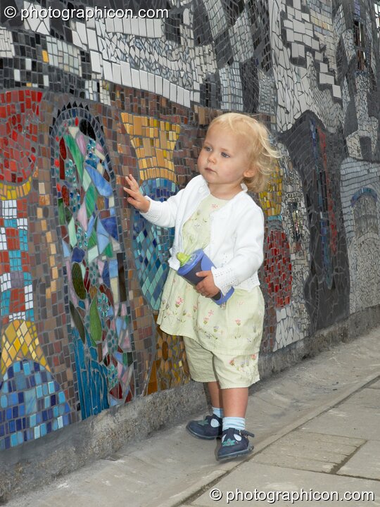 A small child examines the Save The World Club's Hundertwasser mosaic. Kingston Upon Thames, Great Britain. © 2005 Photographicon