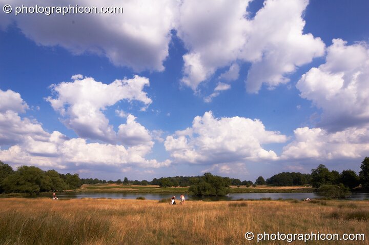 Fluffy clouds in the blue sky over Pen Ponds In Richmond Park. Kingston Upon Thames, Great Britain. © 2005 Photographicon