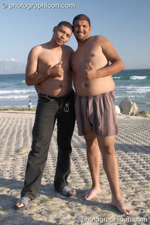 Two men pose shoulder to shoulder on Mnandi Beach, Cape Town - Western Cape, South Africa. © 2005 Photographicon