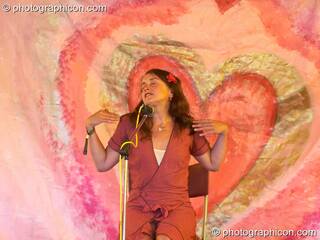 Jo Raphael performs the Vagina Monologues against a heart painted backdrop on the Eartheart Stage at Sunrise Celebration 2006. Yeovil, Great Britain. © 2006 Photographicon