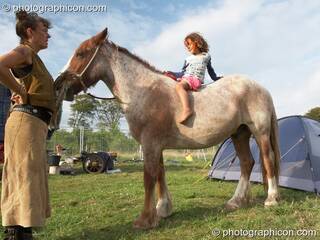 A small girl sitting on horse back in the Horse-drawn Camp at Big Green Gathering 2006. Burrington, Cheddar, Great Britain. © 2006 Photographicon
