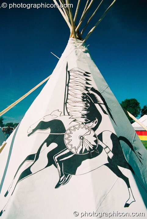 Apache warrior motif on the side of a tipi against deep blue sky at Big Green Gathering 2003. Cheddar, United Kingdom. © 2003 Photographicon