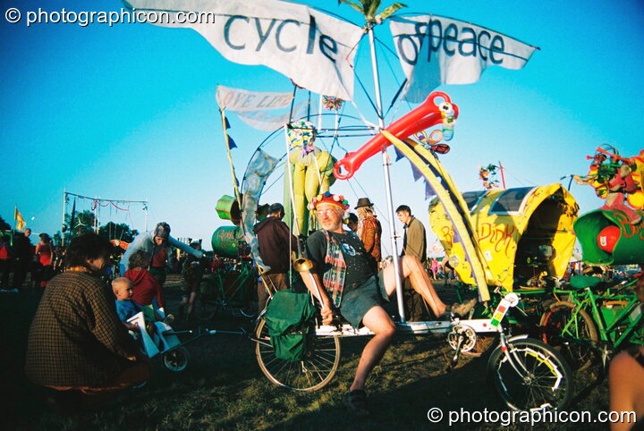 Professor Des Kay takes his son for a ride in his bicycle-drawn chariot at Big Green Gathering 2003. Cheddar, United Kingdom. © 2003 Photographicon