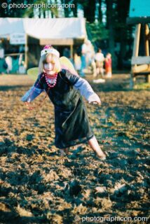 Girl in angel wings and Wellington boots caught in the mud at Big Green Gathering 2003. Cheddar, United Kingdom. © 2003 Photographicon