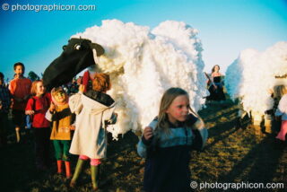A group of kids flock around a pantomime sheep at Big Green Gathering 2003. Cheddar, United Kingdom. © 2003 Photographicon