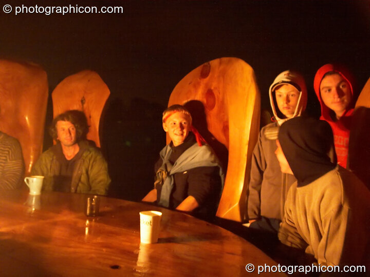 People gathered around a very large wooden table and chairs at Big Green Gathering 2005. Burrington, Cheddar, United Kingdom. © 2005 Photographicon