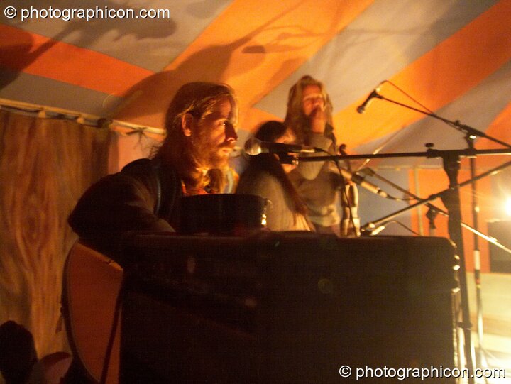Musicians perform by the light of an oil lamp at Big Green Gathering 2005. Burrington, Cheddar, United Kingdom. © 2005 Photographicon