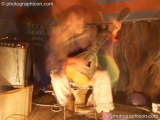 Man playing at lute at Big Green Gathering 2005. Burrington, Cheddar, United Kingdom. © 2005 Photographicon