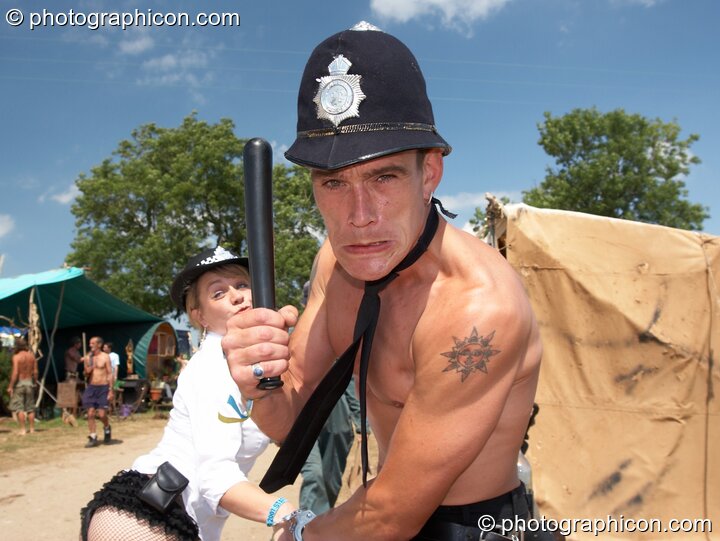 A man and woman partially dressed as pretend police oficers warn the photographer to jolly well behave at Big Green Gathering 2007. Burrington, Cheddar, United Kingdom. © 2007 Photographicon