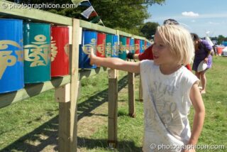 A boy turns the Tibetan Buddhist prayer wheels in the Healing Field at Big Green Gathering 2007. Burrington, Cheddar, United Kingdom. © 2007 Photographicon