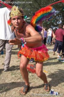 Man wearing orange mini-skirt, fairy wings, and a gold tiara dances by Origin Stage at Glade Festival 2005. Aldermaston, United Kingdom. © 2005 Photographicon