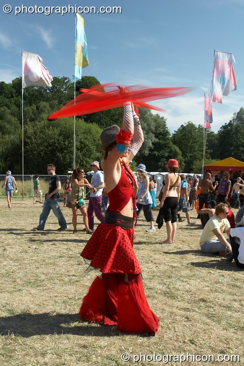 Girl in red twirls red poi above her head at Glade Festival 2005. Aldermaston, United Kingdom. © 2005 Photographicon