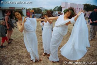 Three women dressed as though in ancient Greece perform a theatrical dance at Glastonbury Festival 2002. Pilton, United Kingdom. © 2002 Photographicon