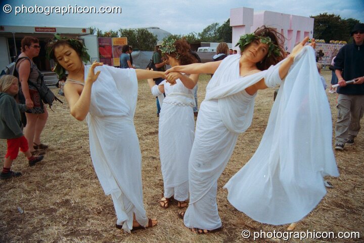 Three women dressed as though in ancient Greece perform a theatrical dance at Glastonbury Festival 2002. Pilton, United Kingdom. © 2002 Photographicon