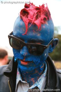 A man with a peeling acrylic painted head in the Lost Vaguess field at Glastonbury Festival 2002. Pilton, United Kingdom. © 2002 Photographicon