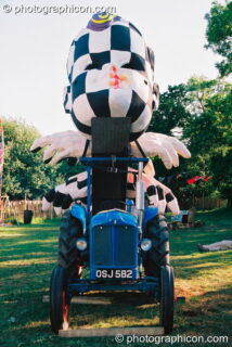 A sculpture of a head attached to a tractor in the Lost Vagueness field at Glastonbury Festival 2003. Pilton, United Kingdom. © 2003 Photographicon