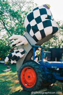 A sculpture of a head attached to a tractor in the Lost Vagueness field at Glastonbury Festival 2003. Pilton, United Kingdom. © 2003 Photographicon