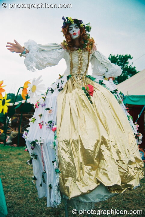 Woman on stilts in a big dress at Glastonbury Festival 2003. Pilton, United Kingdom. © 2003 Photographicon
