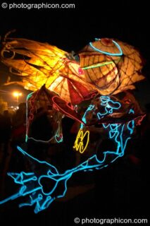 Two people wearing illuminated costumes with large heads and arms embrace at Glastonbury Festival 2004. Pilton, United Kingdom. © 2004 Photographicon