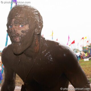 Man with a leery expression is covered head to foot in mud at Glastonbury Festival 2005. Pilton, United Kingdom. © 2005 Photographicon