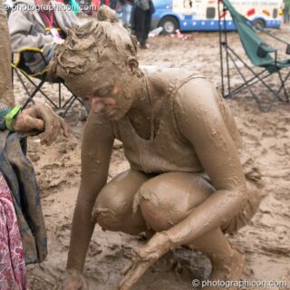 Woman wearing a T-shirt is covered head to foot in mud at Glastonbury Festival 2005. Pilton, United Kingdom. © 2005 Photographicon