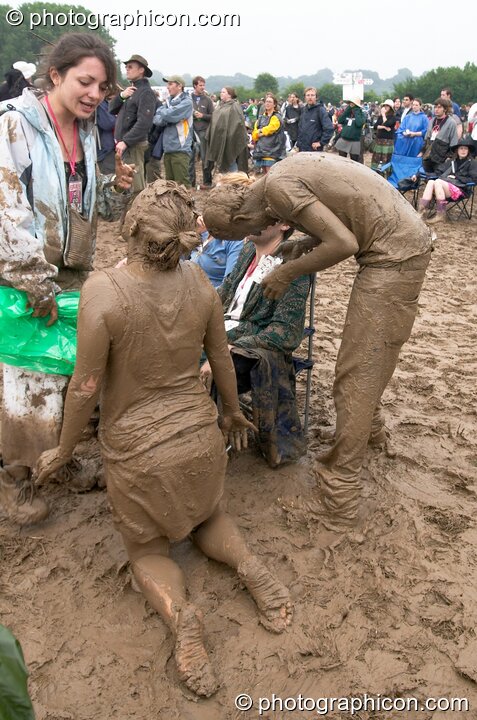 A couple of mud lovers playing at Glastonbury Festival 2005. Pilton, United Kingdom. © 2005 Photographicon