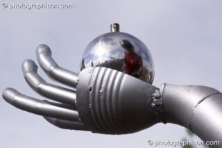 Mutoid Waste Company sculpture of a tall robot holding a reflective perfume ball in Trash City at Glastonbury Festival 2007. Pilton, United Kingdom. © 2007 Photographicon